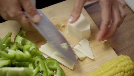 Woman-slicing-cheese-on-cutting-board